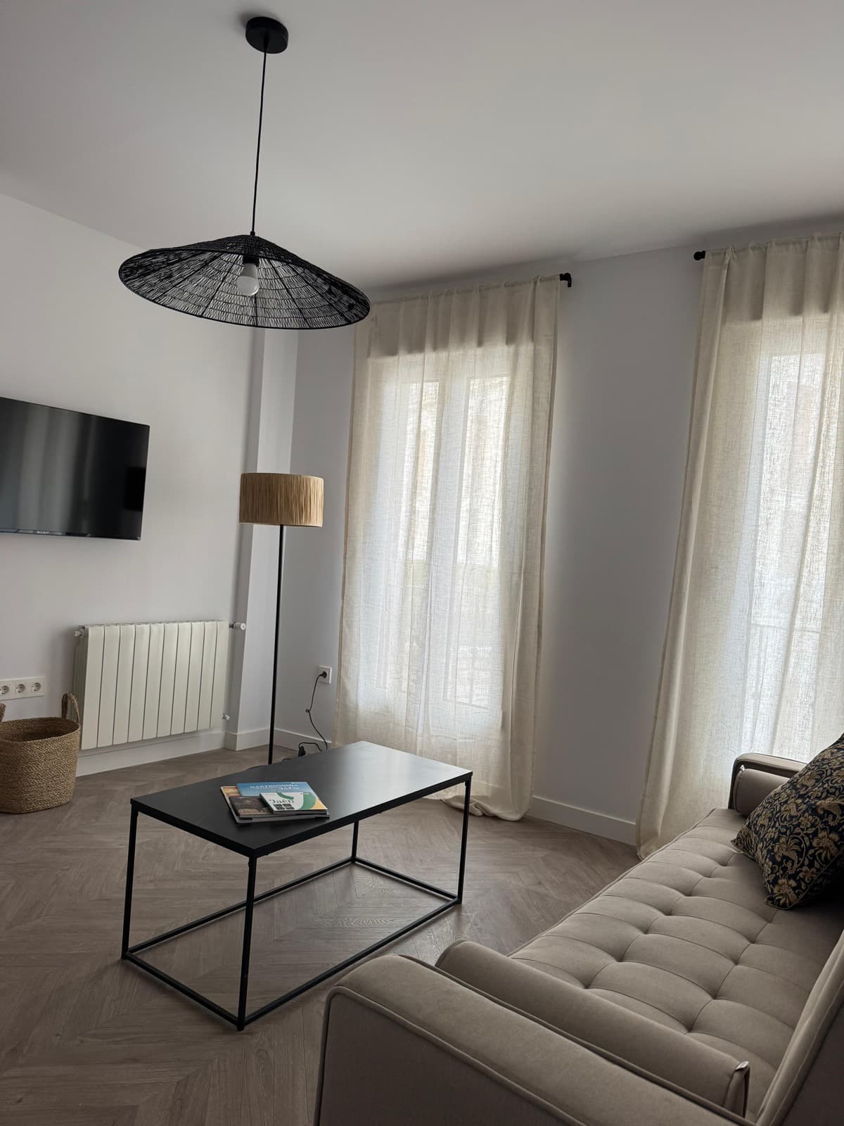 Salón luminoso con sofá, TV y suelo de espiga